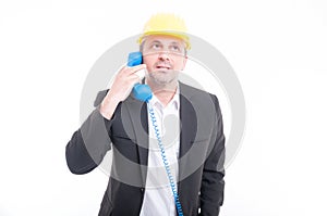 Portrait of architect talking on blue big telephone receiver