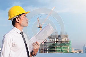 Portrait of architect wear yellow helmet safty on construction site with crane background photo