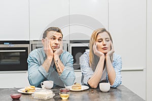 portrait of argued couple sitting at table with breakfast photo