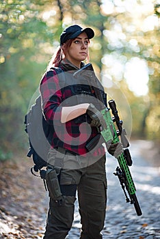 Portrait of an armed girl in the forest