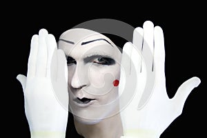 Portrait of artful peeping mime in white gloves