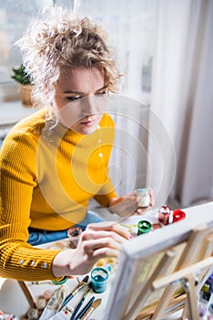 Portrait of an artist girl who creates a painting at home