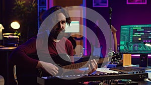 Portrait of artist recording tunes on daw software with his guitar