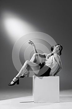 Portrait of artistic woman in character of famous fashion designer posing in stylish classic suit. Black and white