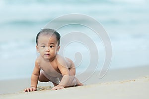 Portrait of asain infant crawling on beautiful sea beach