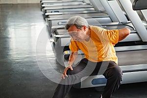 Portrait asia senior man have a backache after running treadmill in fitness gym