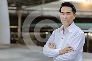 Portrait Asian adult man with smile face Confident business man in white shirt looking at camera while standing outdoors in city