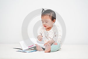 Portrait of asian baby girl, reading a Storybook.