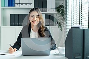 Portrait of Asian beautiful business woman smile while work in office. Attractive professional female employee worker in formal