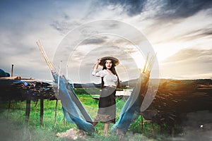 Asian Beautiful woman in Thai local dress standing and working with fishing net in fishing village with field and lake