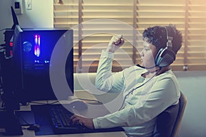 Portrait of asian boy gamer playing games on computer in the room at home