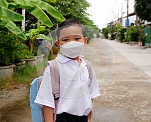 Portrait of Asian boy student in school uniform wearing a white shirt with backpack wearing mask go to school, back to school