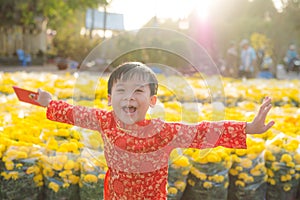 Portrait of a Asian boy on traditional festival costume. Cute little Vietnamese boy in ao dai dress smiling. Tet holiday. Lunar