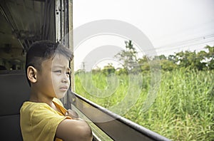 Portrait of asian boy on the train background window views and trees