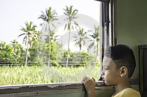 Portrait of asian boy on the train background window views and trees