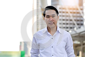 Portrait Asian business man with smile face Confident businessman in white shirt looking at camera while standing outdoors in city