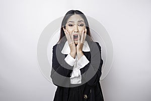 A portrait of an Asian business woman wearing a black suit isolated by white background looks depressed