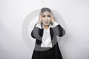 A portrait of an Asian business woman wearing a black suit isolated by white background looks depressed