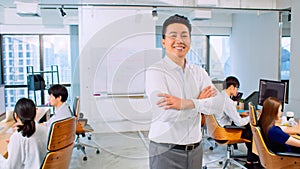 Portrait of Asian businessman, manager or business owner, arms crossed and smile, with employee or coworker working in office