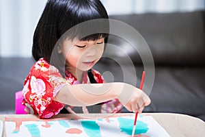 Portrait of Asian child drawing with paintbrush on white paper. Little artist girl happiness with watercolor art.