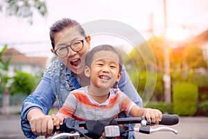 Portrait of asian children riding bicycle with mother smiling face happiness emotion
