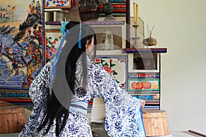 Portrait of Asian Chinese girl in traditional dress, wear blue and white porcelain style Hanfu, do housework in a ancient kitchen