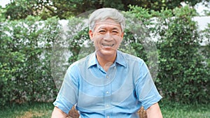 Portrait Asian Chinese senior man feeling happy smiling at home. Older male relax toothy smile looking to camera while lying in