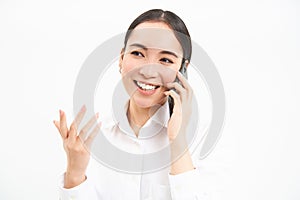 Portrait of asian corporate woman, businesswoman talks on mobile phone, has conversation over cellphone, speaking on