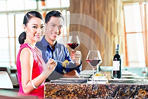 Portrait of Asian couple eating in restaurant