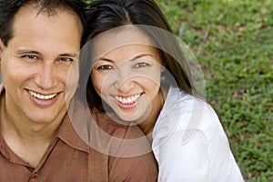 Portrait of an Asian couple laughing and hugging.