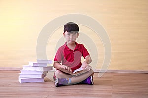 Portrait Asian cute boy.Child boy sitting with a books in room.