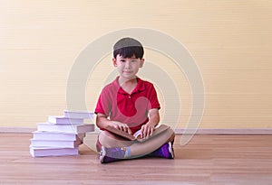 Portrait Asian cute boy.Child boy sitting with a books in room.