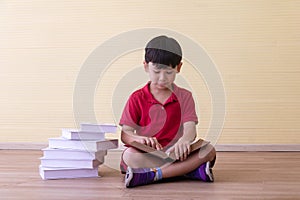 Portrait Asian cute boy.Child boy sitting with a books in room.