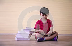 Portrait Asian cute boy.Child boy sitting with a books in room.