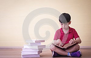 Portrait Asian cute boy.Child boy sitting with a books in room.