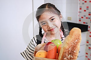 Portrait of an Asian cute kid girl in a kitchen at home. Leisure activity