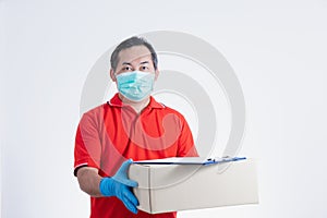 Portrait of Asian delivery man with face medical mask in red cloth holding a box package.