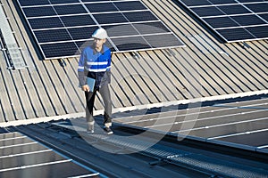 Portrait of Asian engineer on background field of photovoltaic solar panels solar cells on roof top factory.