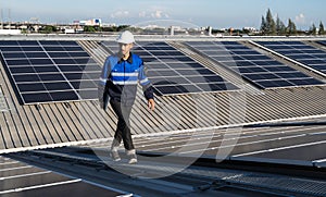 Portrait of Asian engineer on background field of photovoltaic solar panels solar cells on roof top factory.