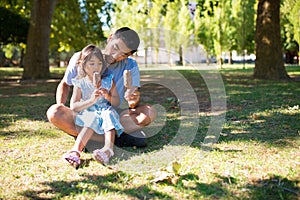 Portrait of Asian father and girl having good day in park