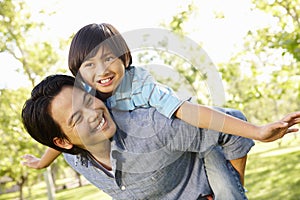 Portrait Asian father and son playing in park