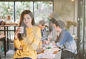 Portrait of asian female creativity working team coworking office ,Smiling of happy beautiful woman Hand Holding Coffee Cup