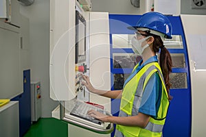 Factory tecnician with face mask working in factory control room photo