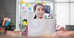 Portrait of asian female leader smiling when meeting with ux developer and ui designer about mobile app interface wireframe design photo