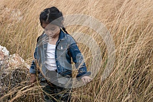 Portrait of asian girl child playing alone in natural grass field