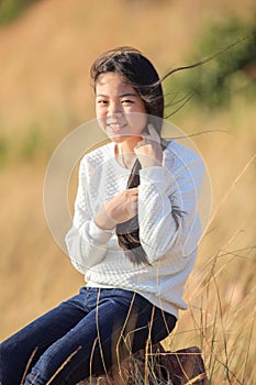 Portrait of asian girl relaxing emotion sitting in grass field a