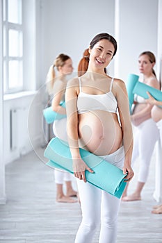 portrait of asian gravid woman in fitness studio room photo