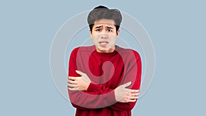 Portrait of asian guy shivering, trembling and feeling cold