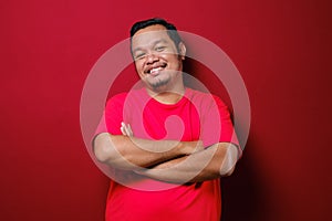 Portrait of Asian handsome man with arms crossed isolate on red background photo