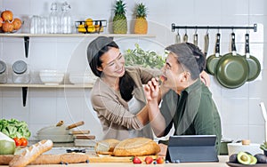 Portrait Asian happy young adult couple lover helping together, holding kitchenware, cooking in cozy home kitchen in morning,